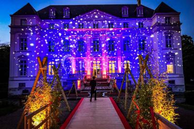 Un couple regarde un feu d'artifice illuminant le ciel nocturne avec des éclats de lumière colorés.