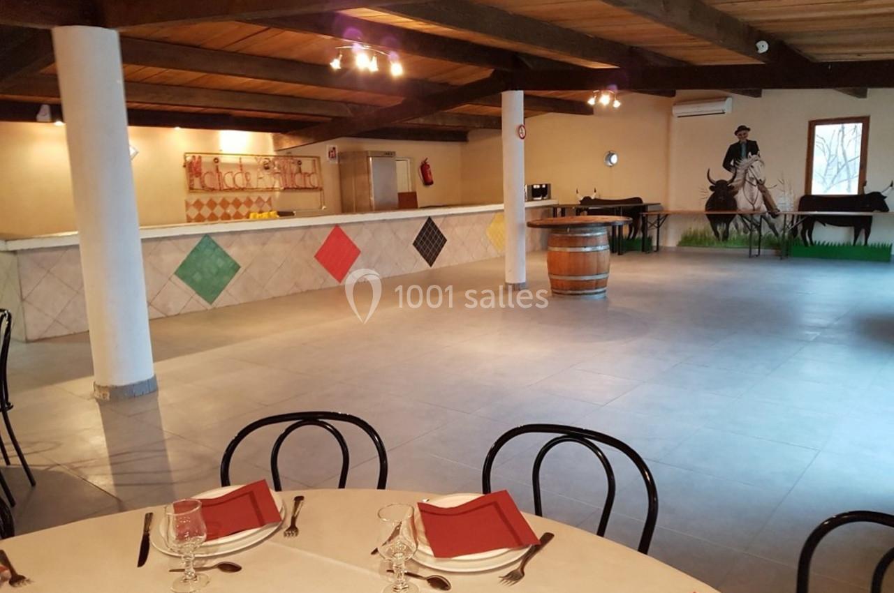 Location salle Arles (Bouches-du-Rhône) - Manade Allard #16 Salle de réception avec tables dressées, comptoir décoré de losanges colorés et fresque murale représentant un cavalier.