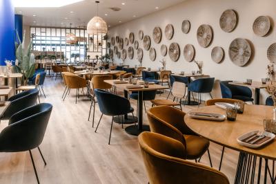 Personnes faisant du vélo d'intérieur en groupe dans une salle de sport lumineuse.