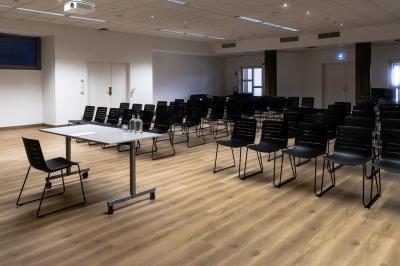 Personnes faisant du vélo d'intérieur en groupe dans une salle de sport lumineuse.