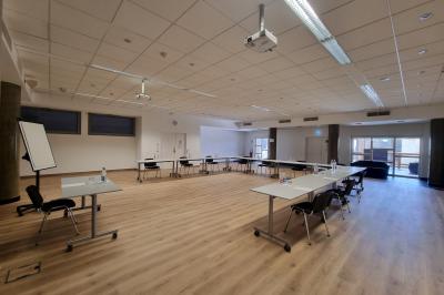 Personnes faisant du vélo d'intérieur en groupe dans une salle de sport lumineuse.