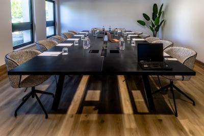 Personnes faisant du vélo d'intérieur en groupe dans une salle de sport lumineuse.