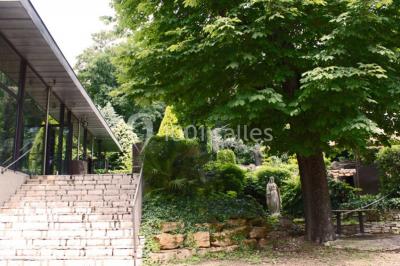 Parking extérieur de nuit, éclairé par des lumières jaunes et entouré d'arbres et de bâtiments.