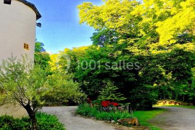 Parking extérieur de nuit, éclairé par des lumières jaunes et entouré d'arbres et de bâtiments.