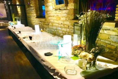 Parking extérieur de nuit, éclairé par des lumières jaunes et entouré d'arbres et de bâtiments.