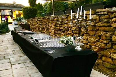 Parking extérieur de nuit, éclairé par des lumières jaunes et entouré d'arbres et de bâtiments.