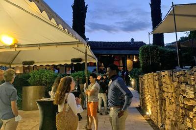 Parking extérieur de nuit, éclairé par des lumières jaunes et entouré d'arbres et de bâtiments.