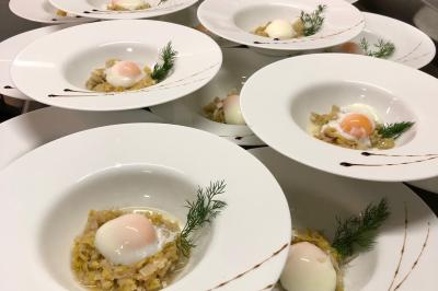 Parking extérieur de nuit, éclairé par des lumières jaunes et entouré d'arbres et de bâtiments.