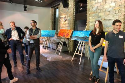 Parking extérieur de nuit, éclairé par des lumières jaunes et entouré d'arbres et de bâtiments.