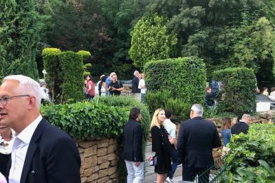 Parking extérieur de nuit, éclairé par des lumières jaunes et entouré d'arbres et de bâtiments.