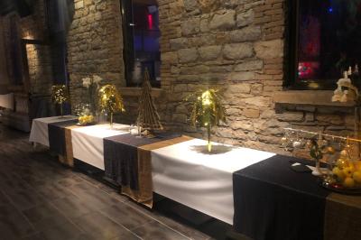 Parking extérieur de nuit, éclairé par des lumières jaunes et entouré d'arbres et de bâtiments.