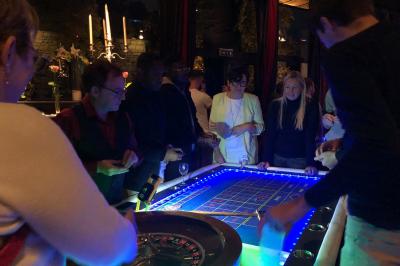 Parking extérieur de nuit, éclairé par des lumières jaunes et entouré d'arbres et de bâtiments.