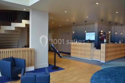 Vue d'une côte avec des falaises, des bâtiments en bord de mer et un ciel partiellement nuageux au crépuscule.