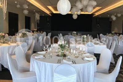 Vue d'une côte avec des falaises, des bâtiments en bord de mer et un ciel partiellement nuageux au crépuscule.