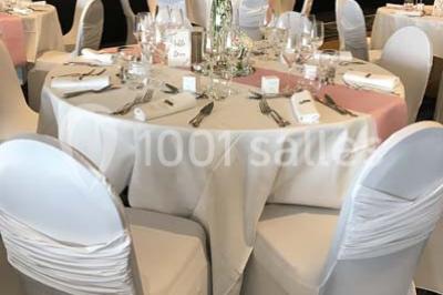 Vue d'une côte avec des falaises, des bâtiments en bord de mer et un ciel partiellement nuageux au crépuscule.