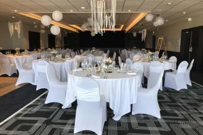 Vue d'une côte avec des falaises, des bâtiments en bord de mer et un ciel partiellement nuageux au crépuscule.