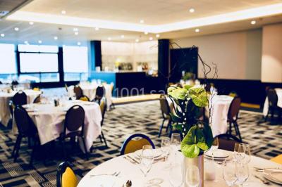 Vue d'une côte avec des falaises, des bâtiments en bord de mer et un ciel partiellement nuageux au crépuscule.