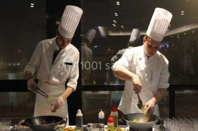 Vue d'une côte avec des falaises, des bâtiments en bord de mer et un ciel partiellement nuageux au crépuscule.