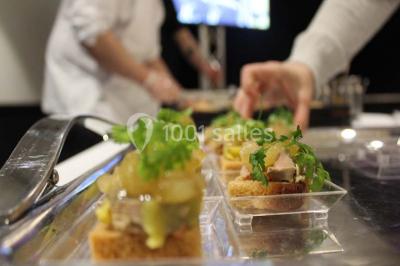 Vue d'une côte avec des falaises, des bâtiments en bord de mer et un ciel partiellement nuageux au crépuscule.