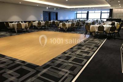Vue d'une côte avec des falaises, des bâtiments en bord de mer et un ciel partiellement nuageux au crépuscule.