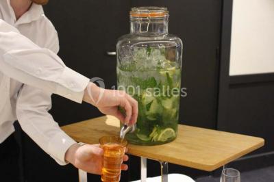 Vue d'une côte avec des falaises, des bâtiments en bord de mer et un ciel partiellement nuageux au crépuscule.