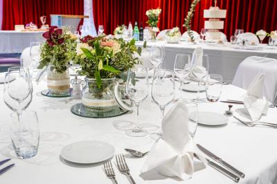Bâtiment moderne en bord de rivière, entouré de verdure, avec un pont piétonnier au premier plan.