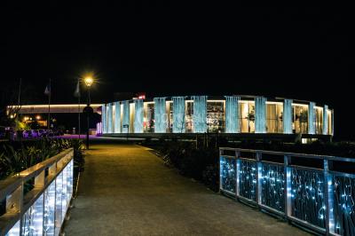 Miniature Location salle Pornic (Loire-Atlantique) - Casino de Pornic #28 Bâtiment circulaire moderne illuminé la nuit, avec un chemin éclairé et des rampes décorées de lumières.