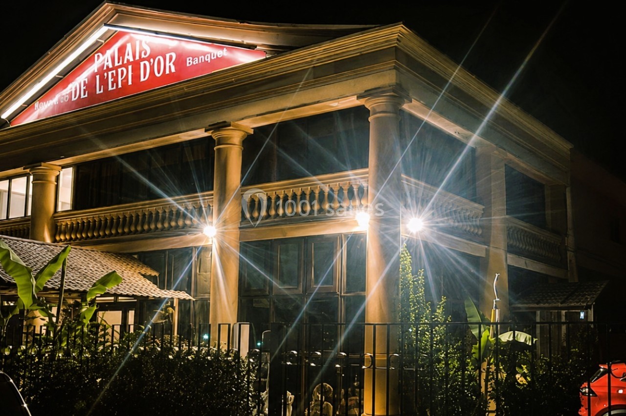 Façade illuminée d'un bâtiment avec une enseigne rouge indiquant ’Palais de l'Épi d'Or’ de nuit.