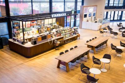Miniature Location salle Conflans-Sainte-Honorine (Yvelines) - Pathé Conflans #7 Comptoir Starbucks dans un espace lumineux avec tables, chaises et grandes baies vitrées en arrière-plan.