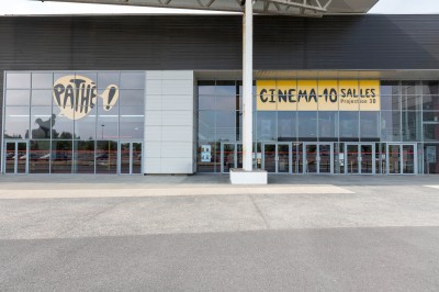 Miniature Location salle Dammarie-les-Lys (Seine-et-Marne) - Pathé Dammarie #2 Salle de cinéma vide avec des rangées de sièges rouges et un projecteur allumé au fond.