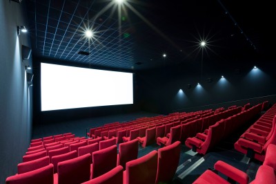 Miniature Location salle Dammarie-les-Lys (Seine-et-Marne) - Pathé Dammarie #8 Salle de cinéma vide avec des rangées de sièges rouges et un projecteur allumé au fond.