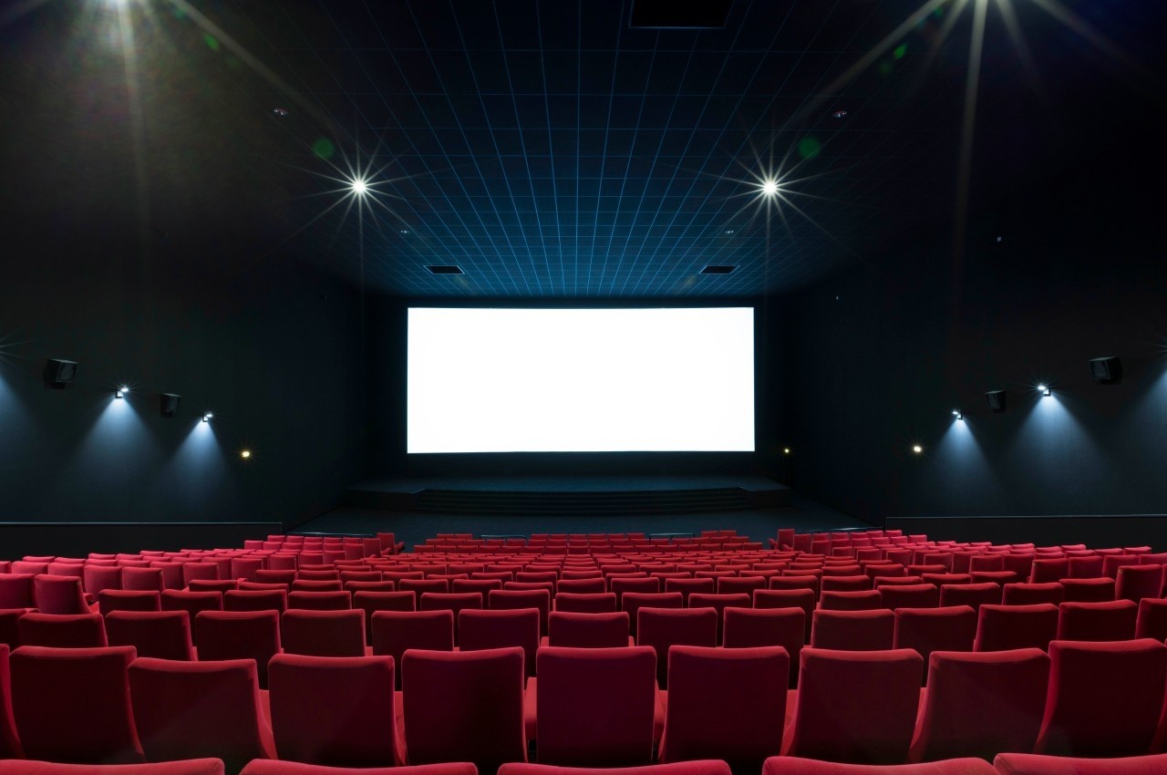Location salle Dammarie-les-Lys (Seine-et-Marne) - Pathé Dammarie #11 Salle de cinéma vide avec des rangées de sièges rouges et un écran blanc allumé au fond.