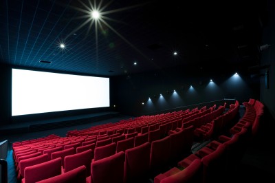 Miniature Location salle Dammarie-les-Lys (Seine-et-Marne) - Pathé Dammarie #13 Salle de cinéma vide avec des rangées de sièges rouges et un projecteur allumé au fond.