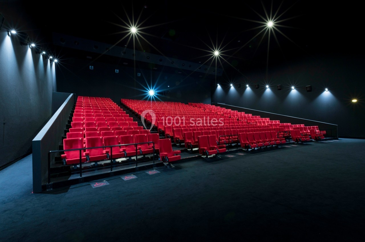 Location salle Dammarie-les-Lys (Seine-et-Marne) - Pathé Dammarie #14 Salle de cinéma vide avec des rangées de sièges rouges et un éclairage tamisé.