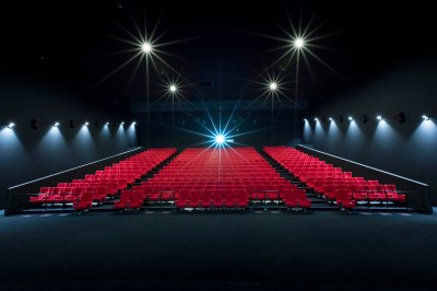 Miniature Location salle Dammarie-les-Lys (Seine-et-Marne) - Pathé Dammarie #15 Salle de cinéma vide avec des rangées de sièges rouges et un projecteur allumé au fond.