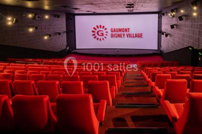 Miniature Location salle Champs-sur-Marne (Seine-et-Marne) - Pathé Disney Village #14 Salle de cinéma vide avec des rangées de sièges rouges, éclairage tamisé et écran en fond.