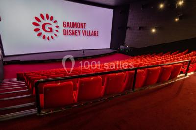 Miniature Location salle Champs-sur-Marne (Seine-et-Marne) - Pathé Disney Village #15 Salle de cinéma vide avec des rangées de sièges rouges, éclairage tamisé et écran en fond.