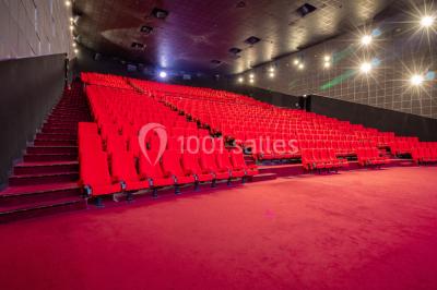 Miniature Location salle Champs-sur-Marne (Seine-et-Marne) - Pathé Disney Village #17 Salle de cinéma vide avec des rangées de sièges rouges, éclairage tamisé et écran en fond.
