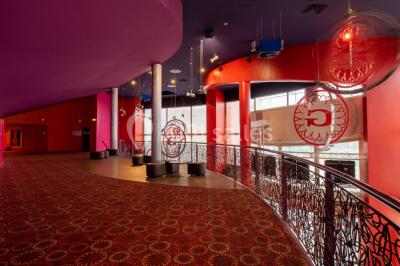 Miniature Location salle Champs-sur-Marne (Seine-et-Marne) - Pathé Disney Village #9 Salle de cinéma vide avec des rangées de sièges rouges, éclairage tamisé et écran en fond.