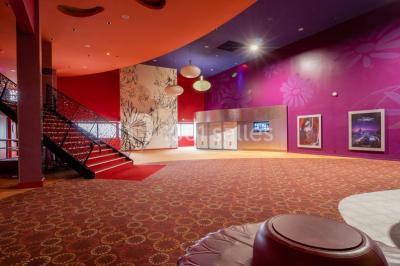 Miniature Location salle Champs-sur-Marne (Seine-et-Marne) - Pathé Disney Village #7 Salle de cinéma vide avec des rangées de sièges rouges, éclairage tamisé et écran en fond.
