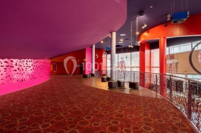 Miniature Location salle Champs-sur-Marne (Seine-et-Marne) - Pathé Disney Village #4 Salle de cinéma vide avec des rangées de sièges rouges, éclairage tamisé et écran en fond.