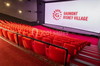 Miniature Location salle Champs-sur-Marne (Seine-et-Marne) - Pathé Disney Village #21 Salle de cinéma vide avec des rangées de sièges rouges, éclairage tamisé et écran en fond.