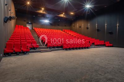 Miniature Location salle Levallois-Perret (Hauts-de-Seine) - Pathé Levallois #13 Salle de cinéma vide avec rangées de fauteuils rouges, éclairage tamisé et écran non visible à l'avant.