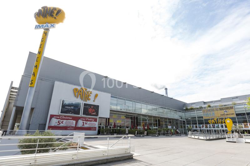 Location salle Ivry-sur-Seine (Val-de-Marne) - Pathé Quai D'ivry #9 Façade d'un cinéma Pathé avec enseigne IMAX, affiches de films et entrée principale entourée de vitrages.