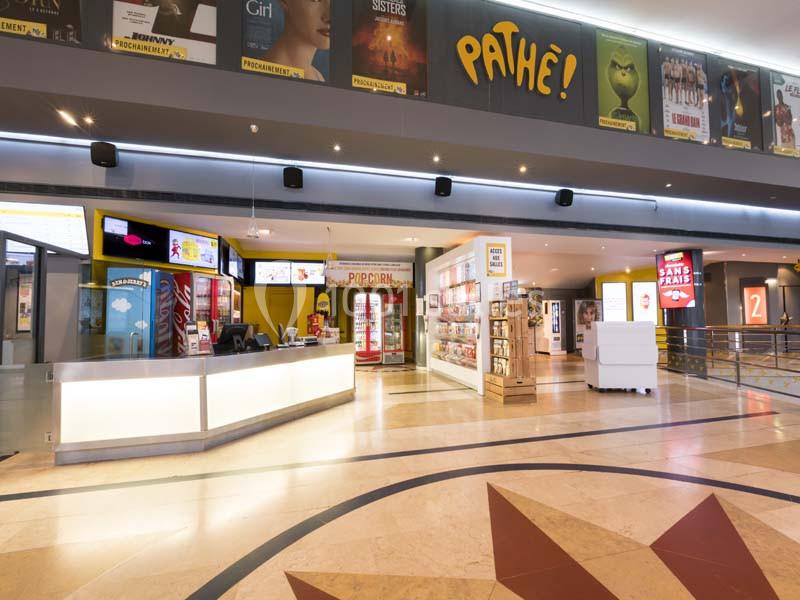 Location salle Boulogne-Billancourt (Hauts-de-Seine) - Pathé Boulogne #11 Hall d'entrée lumineux d'un cinéma Pathé avec comptoirs de billetterie, affiches de films et espace de confiserie.