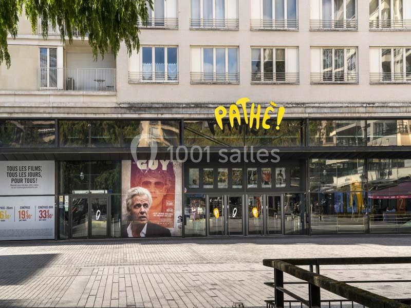 Location salle Boulogne-Billancourt (Hauts-de-Seine) - Pathé Boulogne #24 Façade d'un cinéma Pathé avec une affiche du film ’Guy’ et des vitrines donnant sur une place pavée.