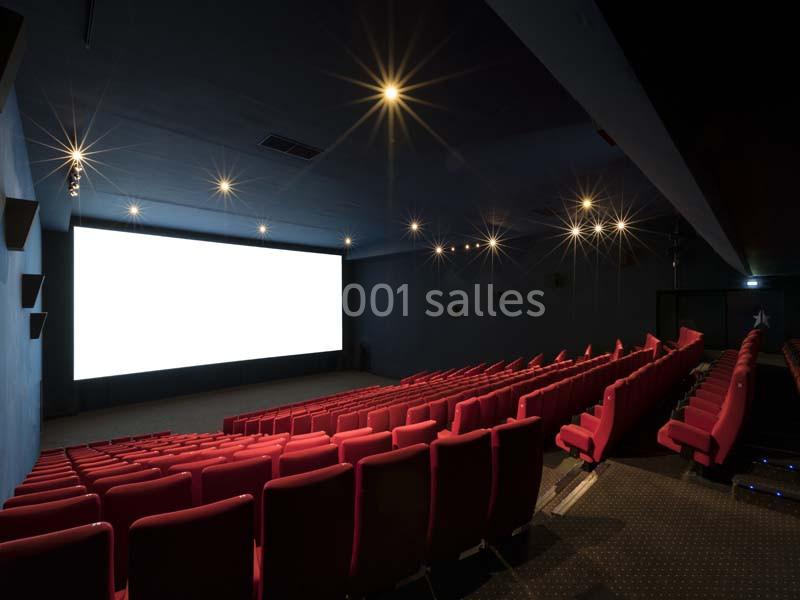 Location salle Boulogne-Billancourt (Hauts-de-Seine) - Pathé Boulogne #4 Salle de cinéma vide avec rangées de sièges rouges et un grand écran blanc allumé.