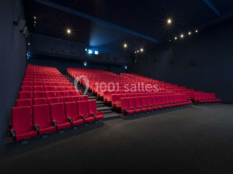Location salle Boulogne-Billancourt (Hauts-de-Seine) - Pathé Boulogne #6 Salle de cinéma vide avec des rangées de sièges rouges et un éclairage tamisé.