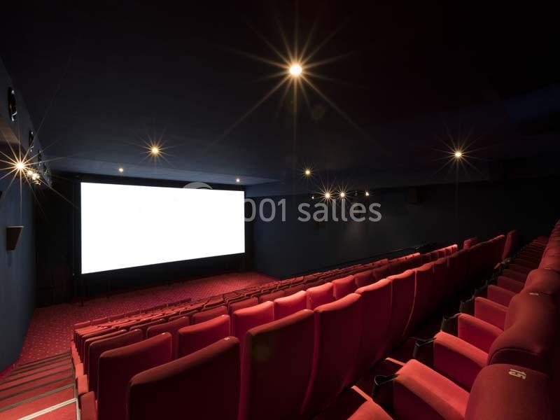 Location salle Boulogne-Billancourt (Hauts-de-Seine) - Pathé Boulogne #8 Salle de cinéma vide avec rangées de sièges rouges et grand écran blanc allumé dans une ambiance sombre.