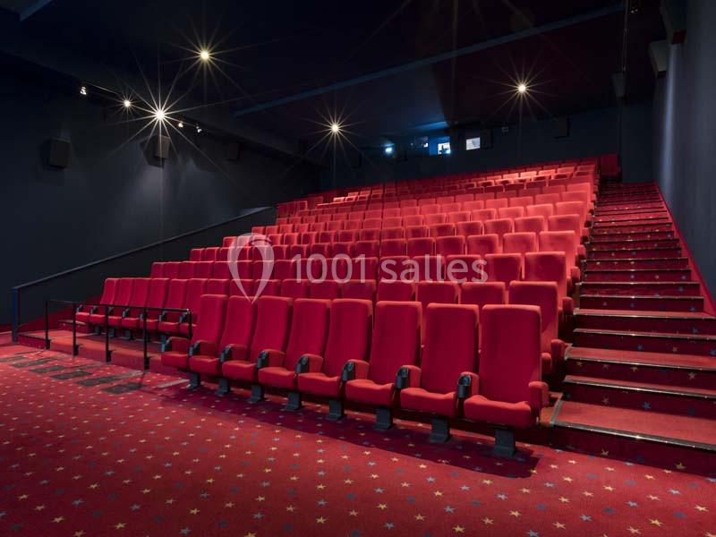 Location salle Boulogne-Billancourt (Hauts-de-Seine) - Pathé Boulogne #16 Salle de cinéma vide avec des rangées de sièges rouges et un sol recouvert d'une moquette étoilée.